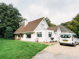 A warm, welcoming detached bungalow in Cornwall showing a flat, accessible entrance, clean driveway parking, and a private green garden, proving why a lease property Cornwall agreement keeps assets preserved.