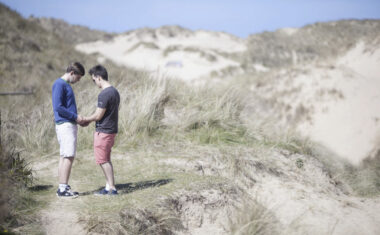 Care worker giving support in sand dunes